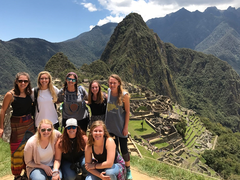 Group of College of Charleston students at Machu Picchu with scenic mountains in the background.
