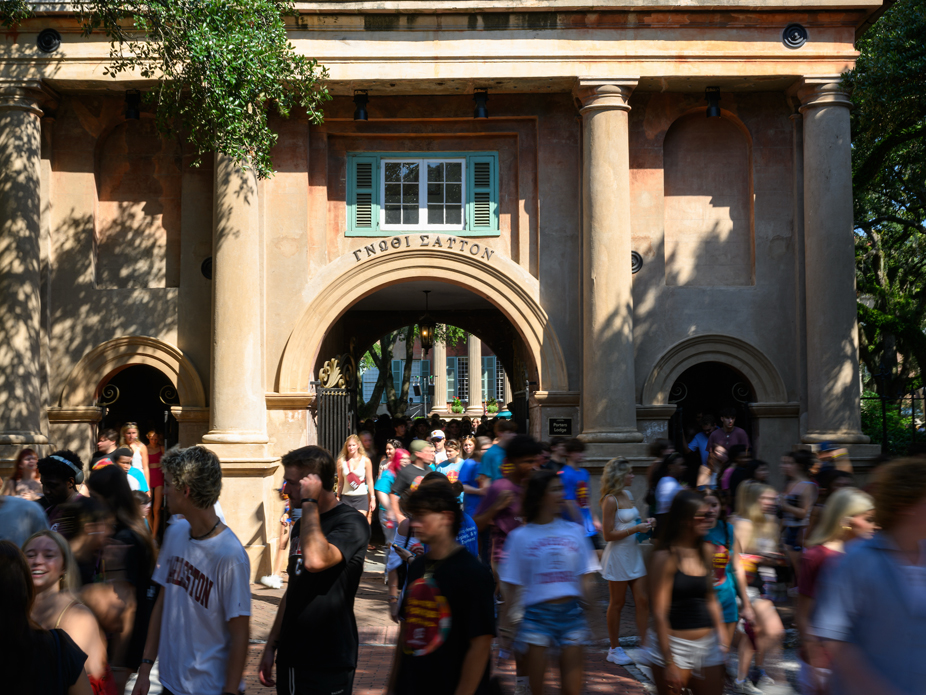 Crowd of students walking through the Porter's Lodge arched entrance.