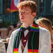 A male College of Charleston student wears a pride graduate stole at the commencement ceremony.