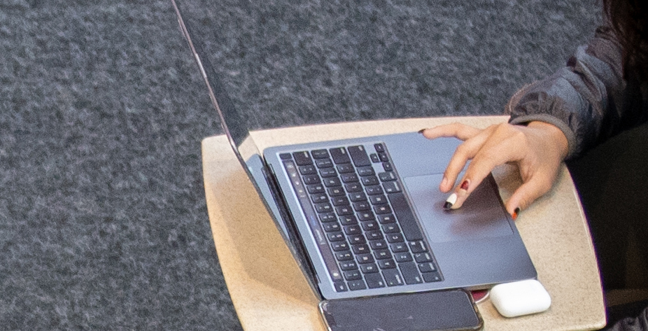 close up of a hand with painted fingernails scrolling the keyboard of a laptop computer.jpg