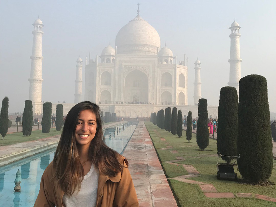 College of Charleston student standing near the entranceway to the Taj Mahal in India. 