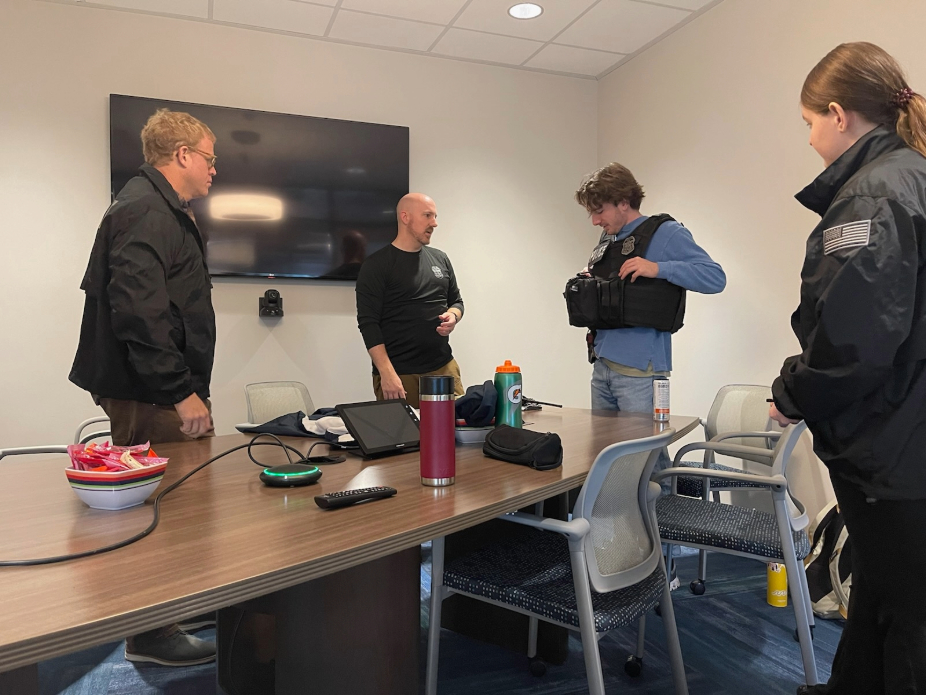 Four people in a classroom putting on investigation gear