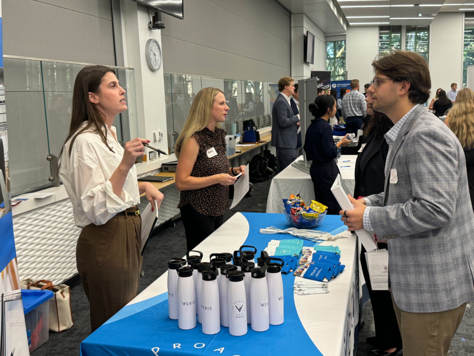 A woman and a man speaking over a table at a job fair