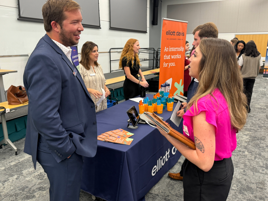 A man and a woman speaking to one another across a table