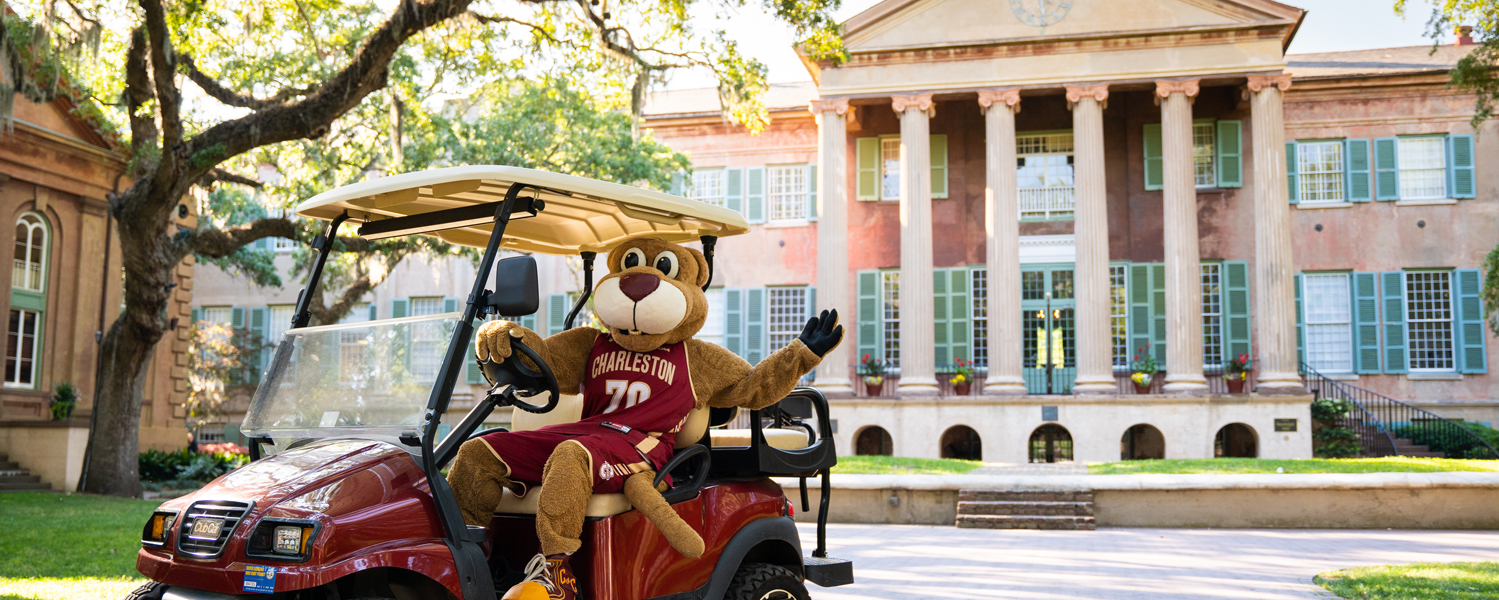 College of Charleston mascot Clyde the Cougar sits in a golf cart in front of Randolph Hall ready to take visitors on an admissions tour.
