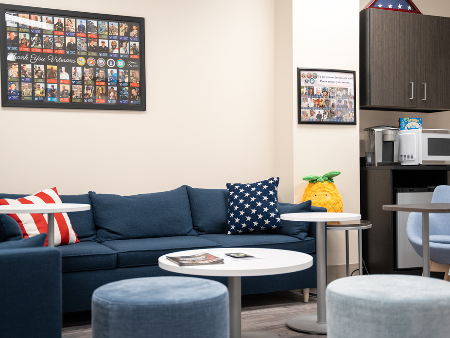 Interior of the veteran and military lounge with comfortable, blue sofas and military-inspired photos and artwork on the walls.