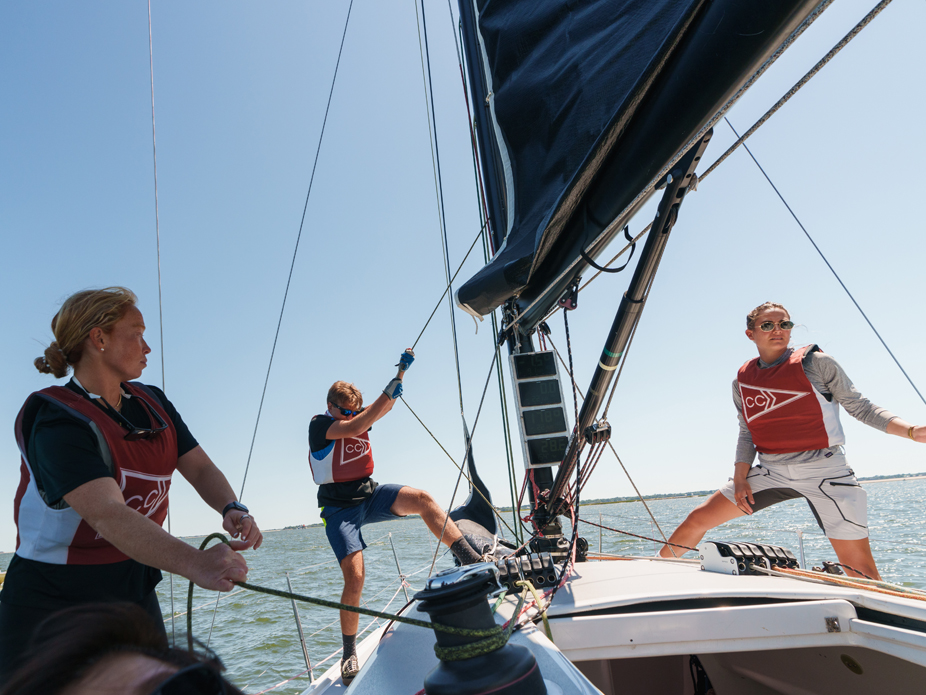 Three College of Charleston students hoist the rigging on one of the College's sailboats.
