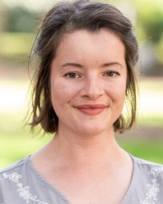 Margaret Cotter, a smiling woman with shoulder-length hair wearing a light gray blouse with floral embroidery.