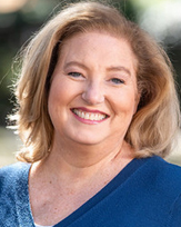 Karen Crush, a smiling woman with blonde hair wearing a blue top, exuding warmth and friendliness.