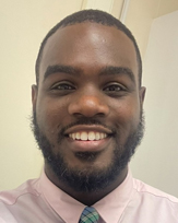 Jonathan Duhart, a smiling man with a beard, wearing a pink dress shirt and a patterned tie.