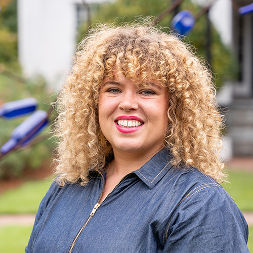African American Female in front of a blue bottle tree