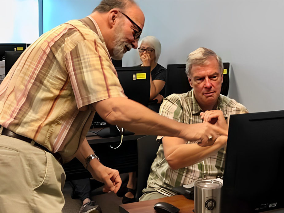 Instructor Tony Young assists a C.A.L.L. participant during a course on video editing.