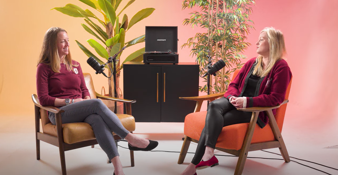 Two women seated having an interview styled conversation