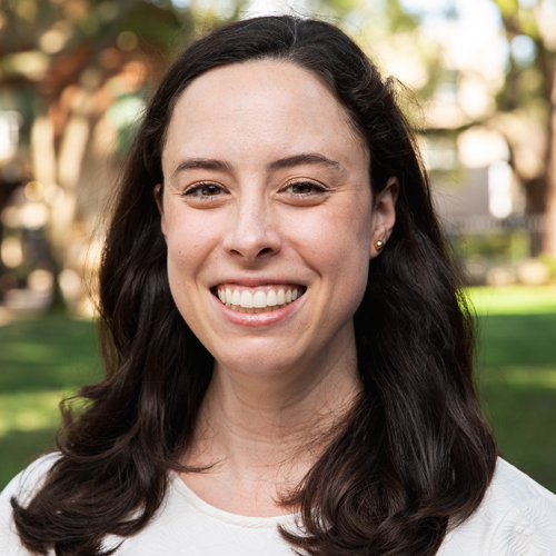 Professional headshot of Blance McCune, a smiling woman with shoulder length brown hair against an outdoor campus background.