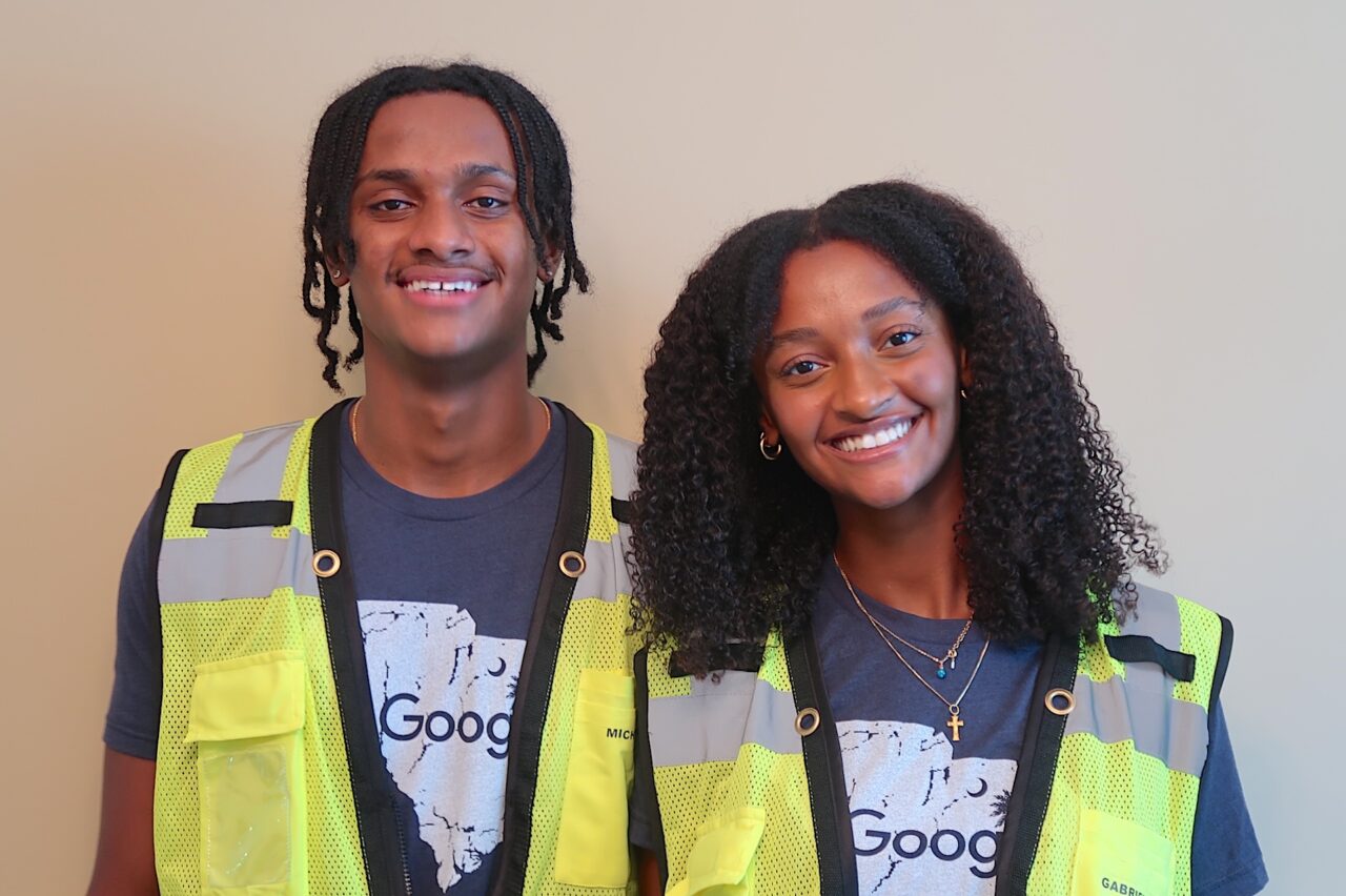 siblings in reflective vests posing for the camera smiling