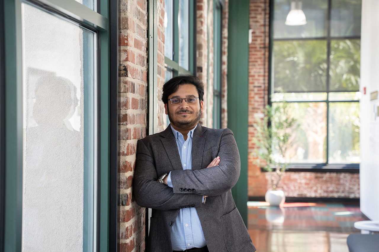 Prof Tiwari standing in a hallway leaning against the wall
