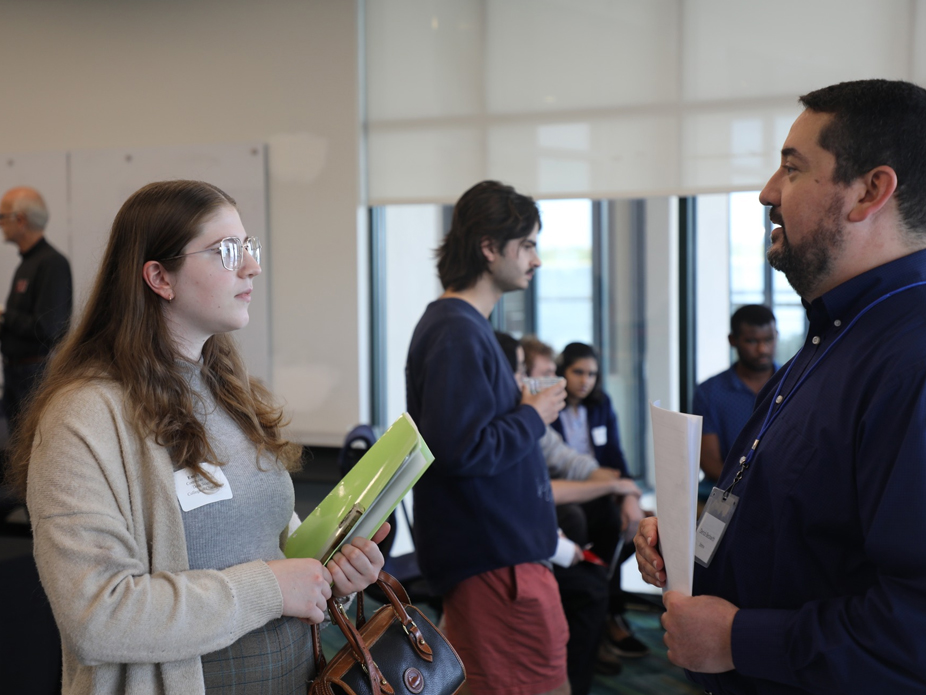 A female student chats with a potential employer at BizBash