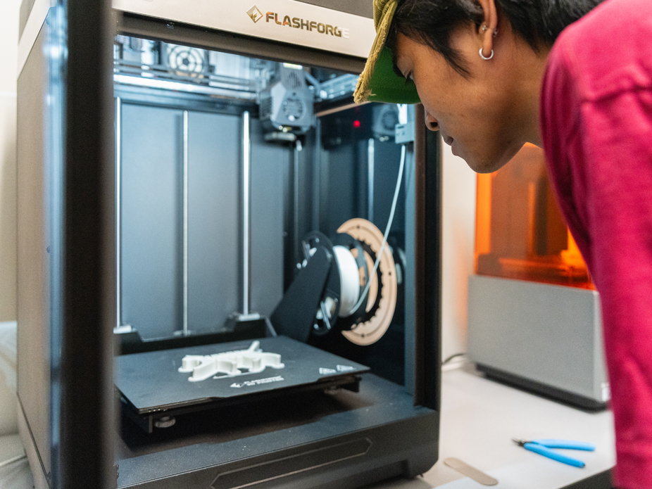 A student operates a FlashForg 3-D printer at the College of Charleston