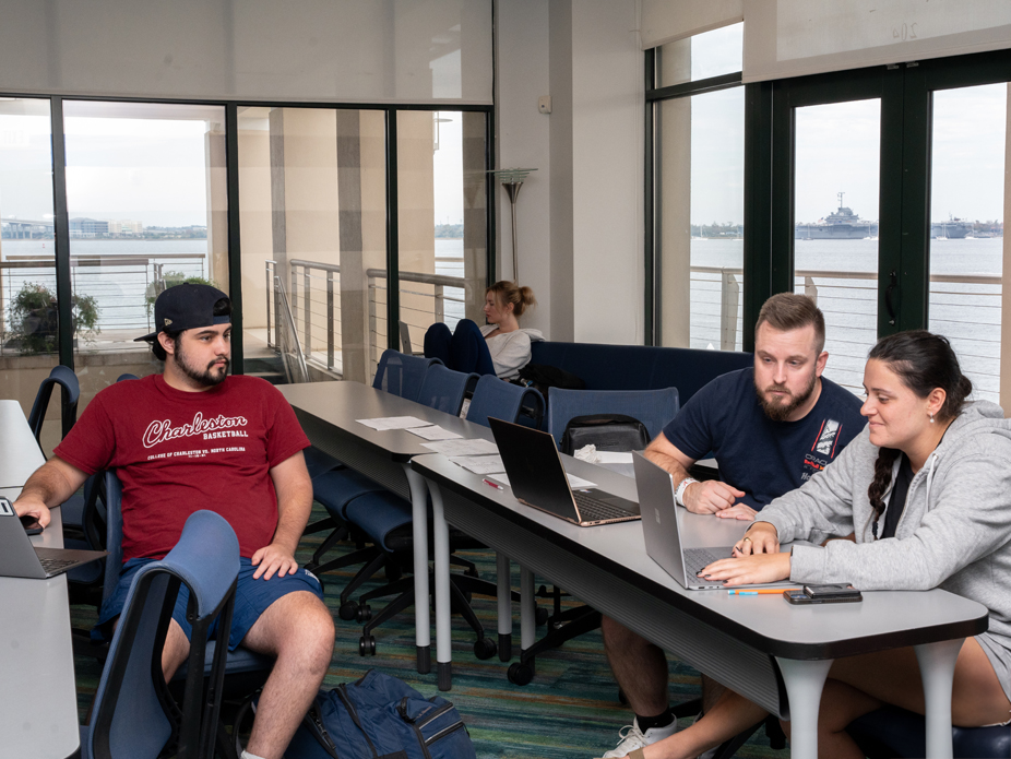 Students collaborate around a laptop computer at the Compute Science Innovation Center.