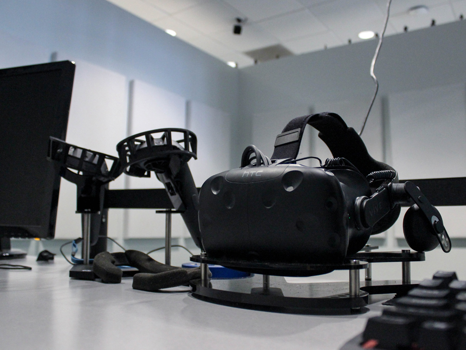 An AI headset sits on a table next to a computer monitor at the College of Charleston.