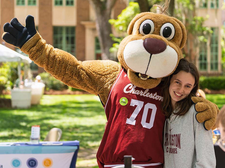 College of Charleston mascot, Clyde the Cougar, hugs student. 