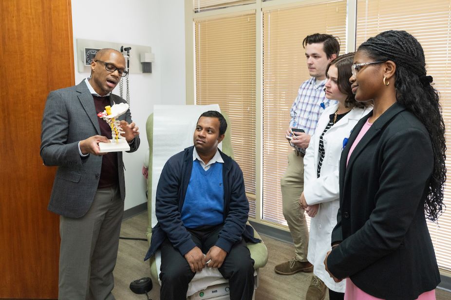 Dr. Nathan Rowland demonstrates a human vertebrae to students in the NUTIP program.