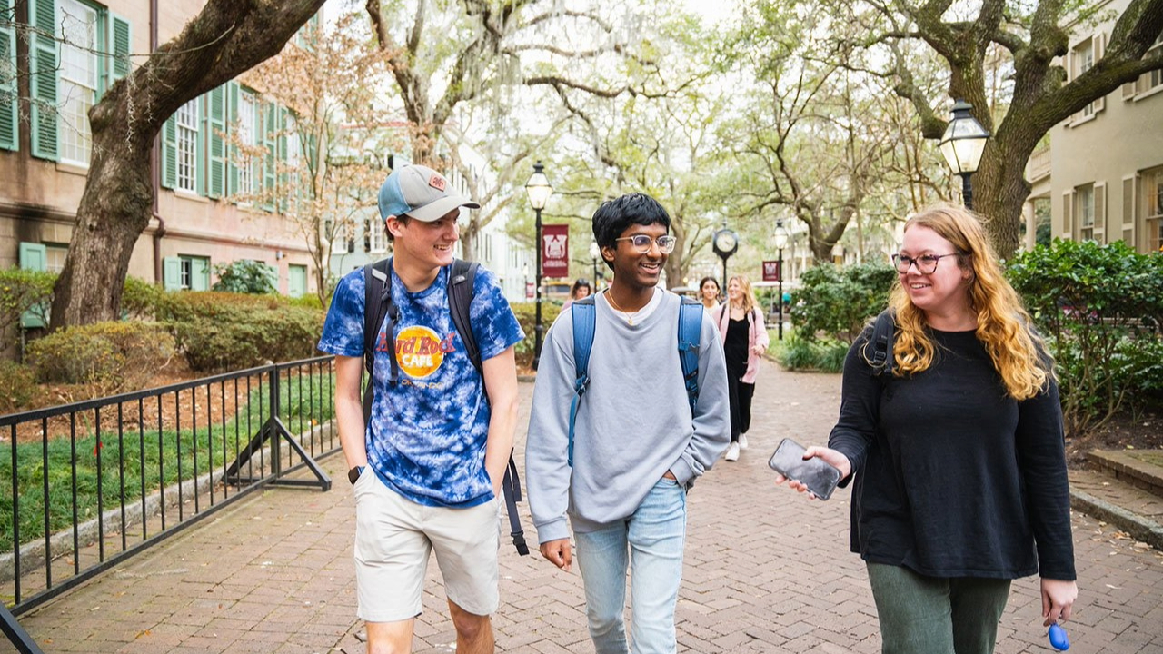 Honors College students walk through campus as they engage in an enraptured discussion.