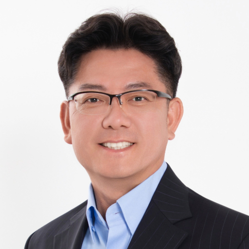 A man with dark hair and glasses smiling