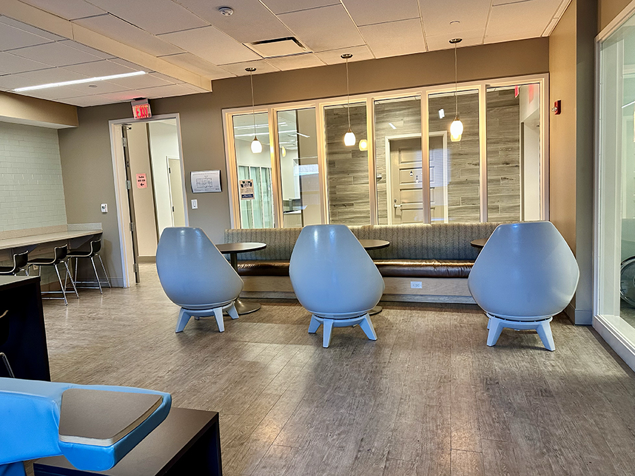 Rutledge lounge with three large chairs, a banquette and round tables