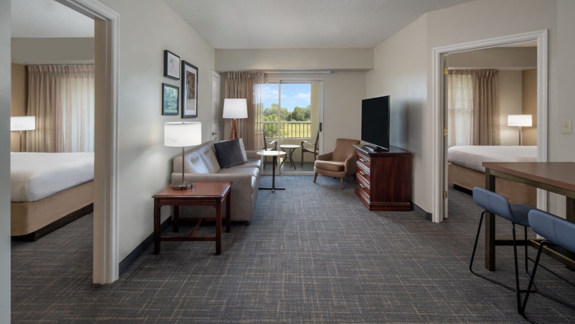 center of hotel suite with queen beds on either side of living area