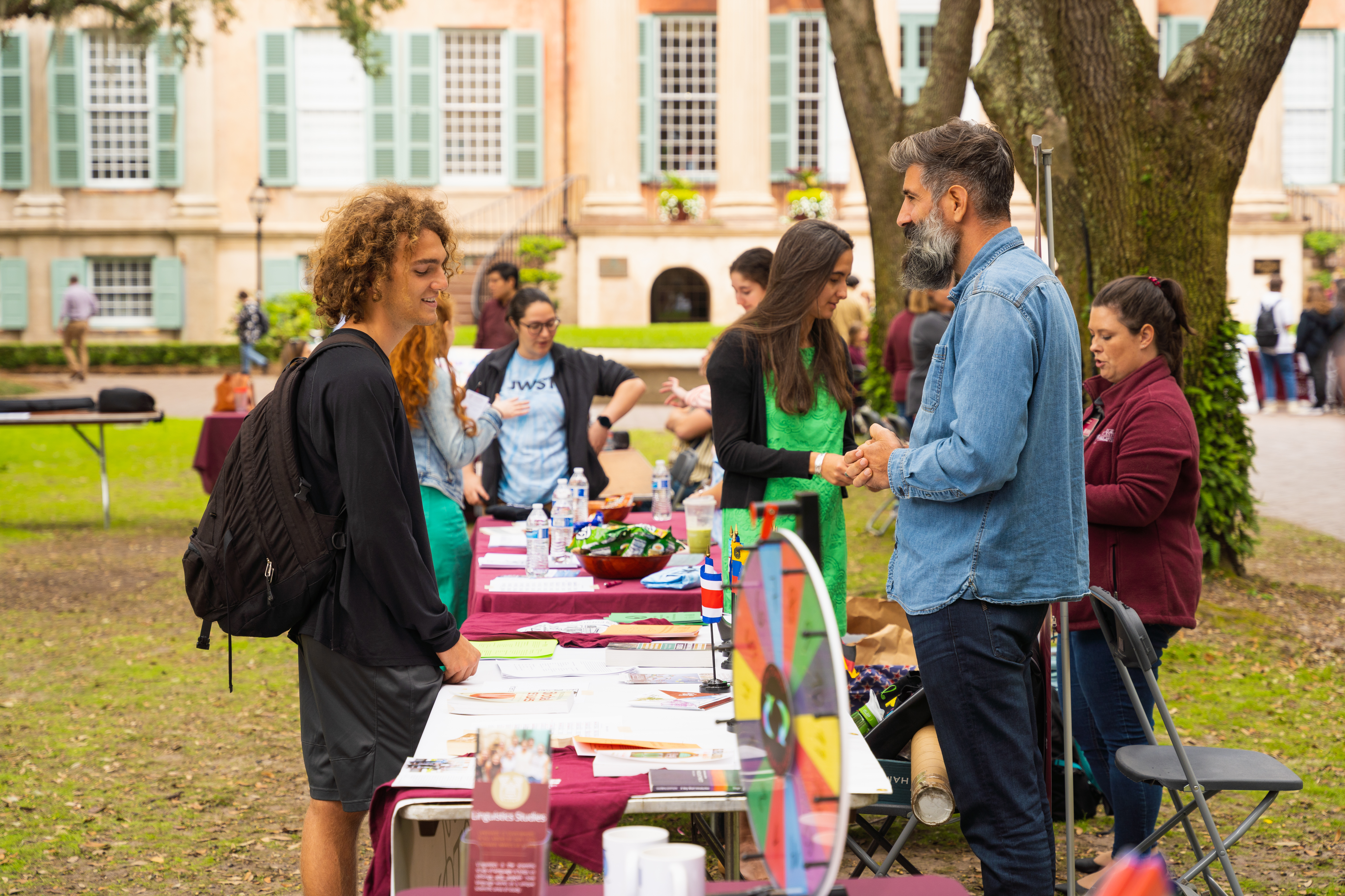 A student and a professor standing on either side of a table with papers relating to the International Studies Program at the Majors-Minors fair.