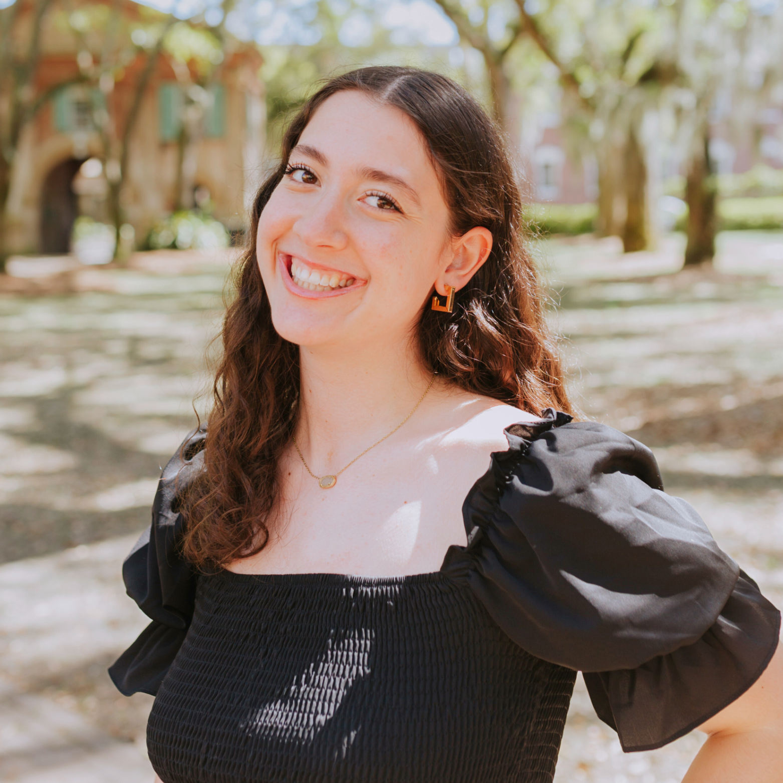 Sophie Baron smiling in front of Porter's Lodge at the College of Charleston.