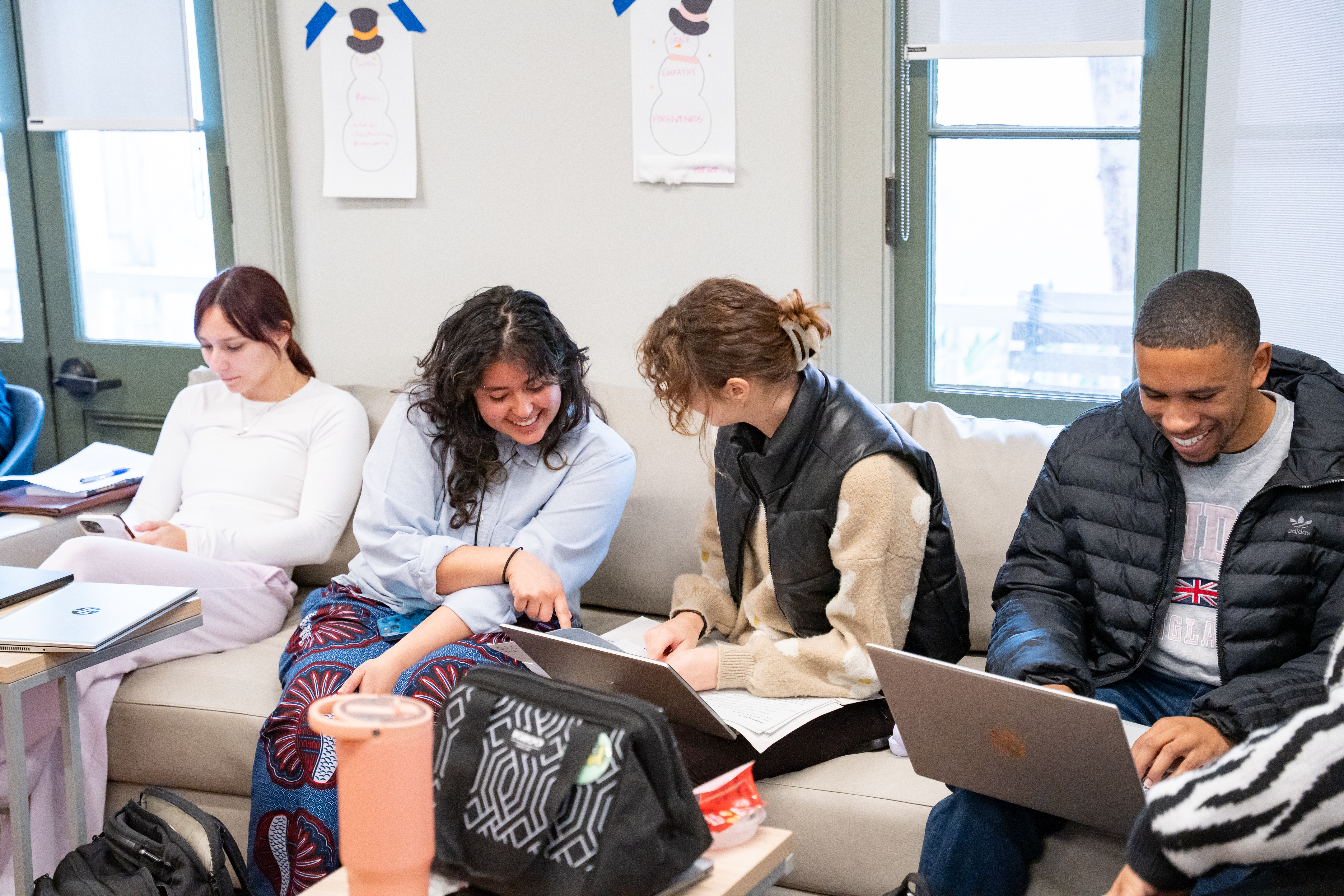Students sit together in the Life Design Center living room during a Life Design coaching session, discussing goals with a coach.