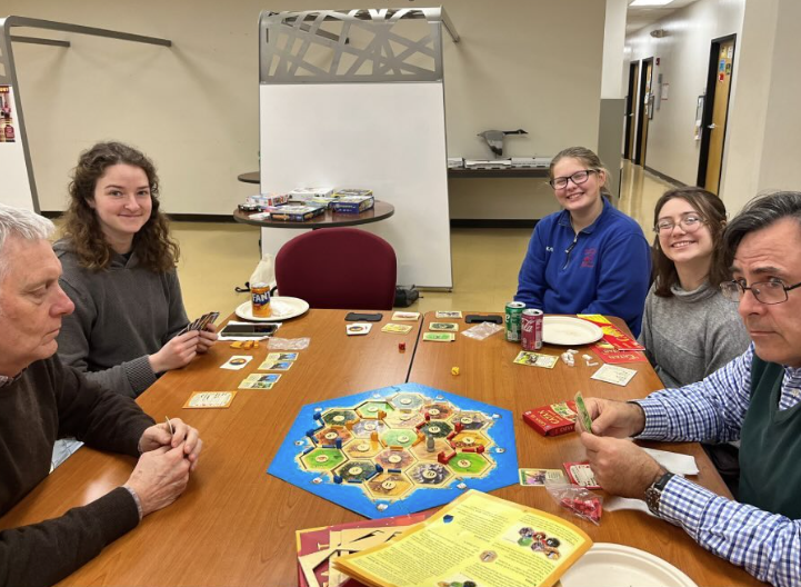 Students and faculty playing board game