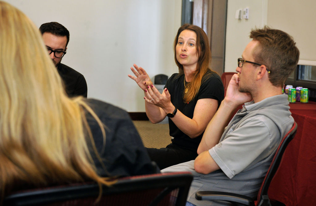 A woman speaking to a small group of seated people