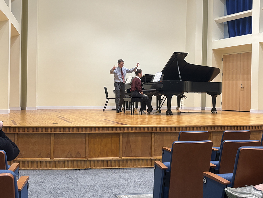 A teacher instructing a piano student. 