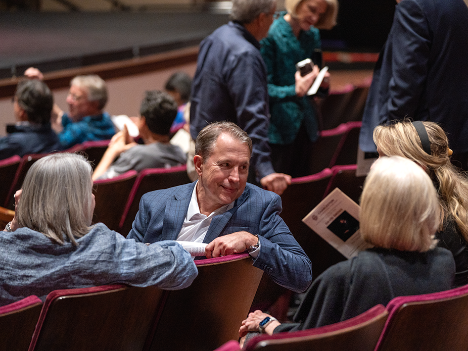 People in a crowd at a piano performance.