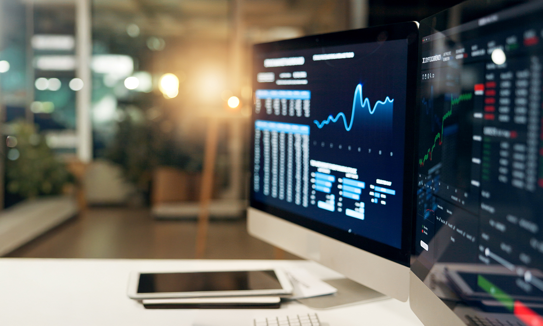 Computer monitors displaying statistics and data in a modern office.