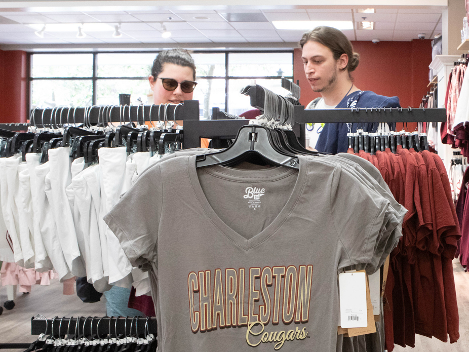 Two individuals look over merchandise at the College of Charleston bookstore.