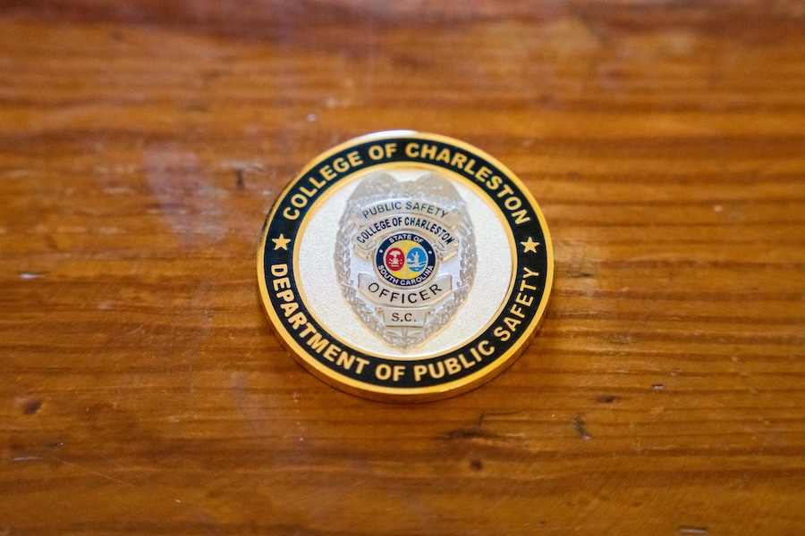 College of Charleston Department of Public Safety officer badge on a wooden surface.