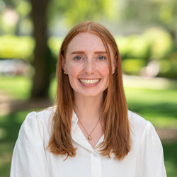 Image of smiling woman with red hair and white blouse