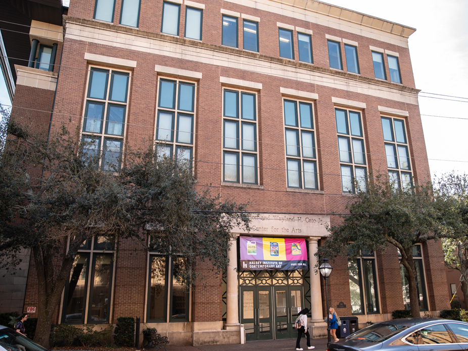 Exterior view of the Cato Center for the Arts at the College of Charleston, a three-story red-brick building with large rows of windows. 