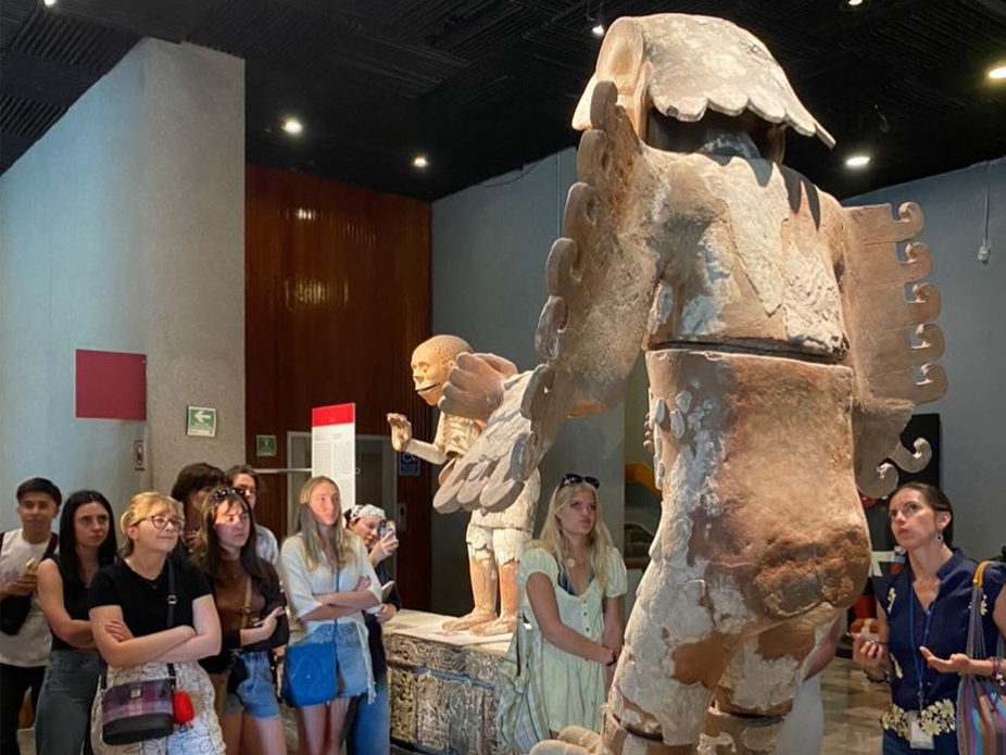 College of Charleston students observing ancient sculptures in a museum exhibit.