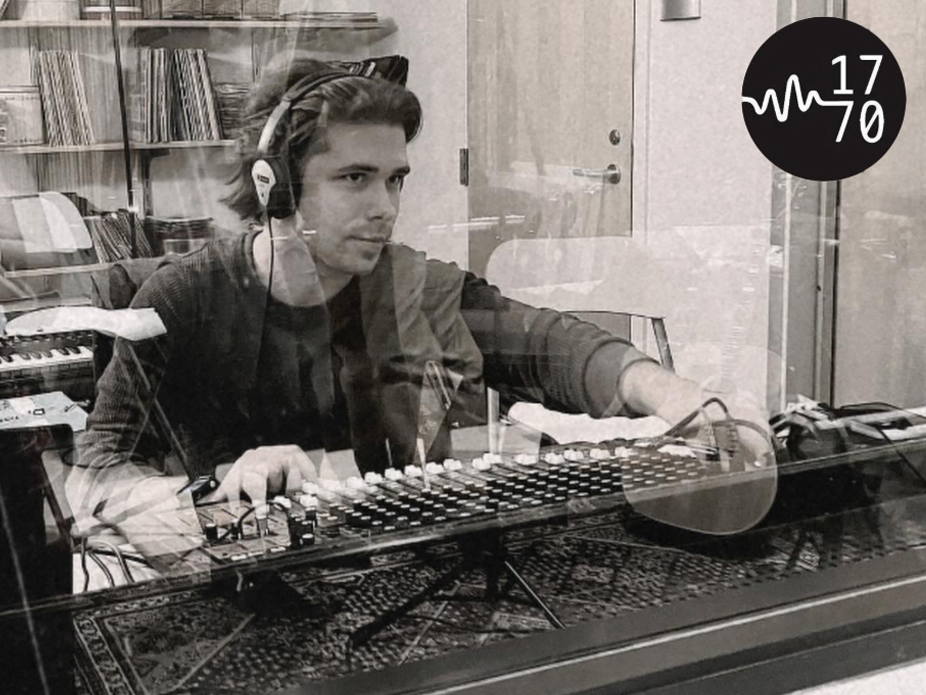 A College of Charleston student at a mixing console inside a recording studio, with vinyl records visible in the background. The image includes a logo in the top right corner.