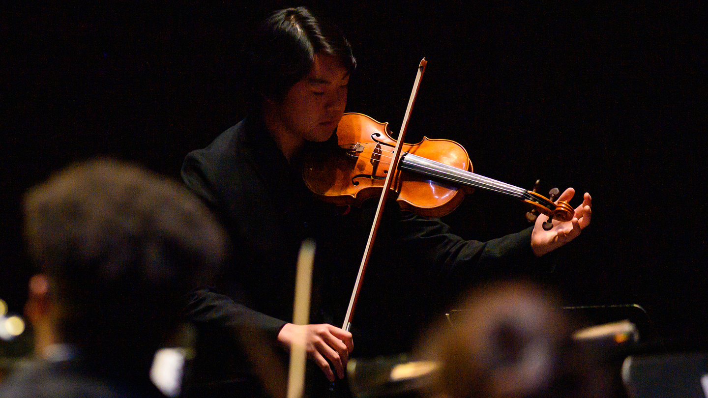 Violin student performing in orchestra concert