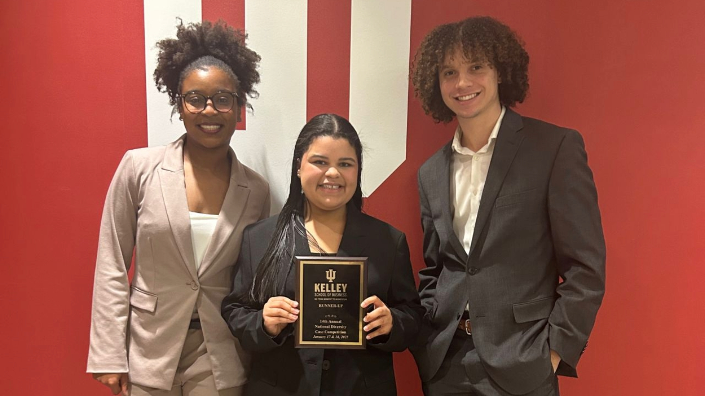 THree student smiling with an award