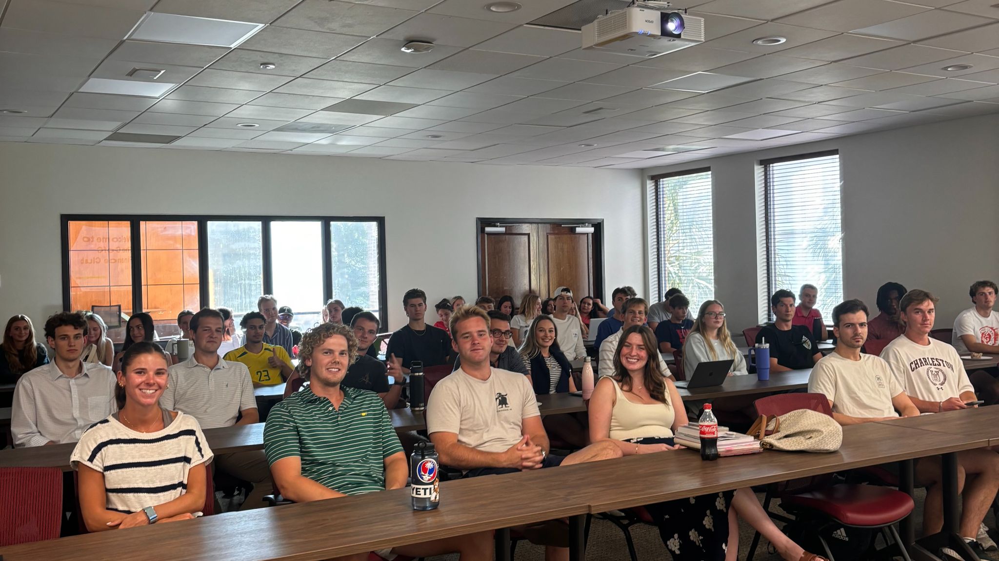 A group of students smiling in a classroom.
