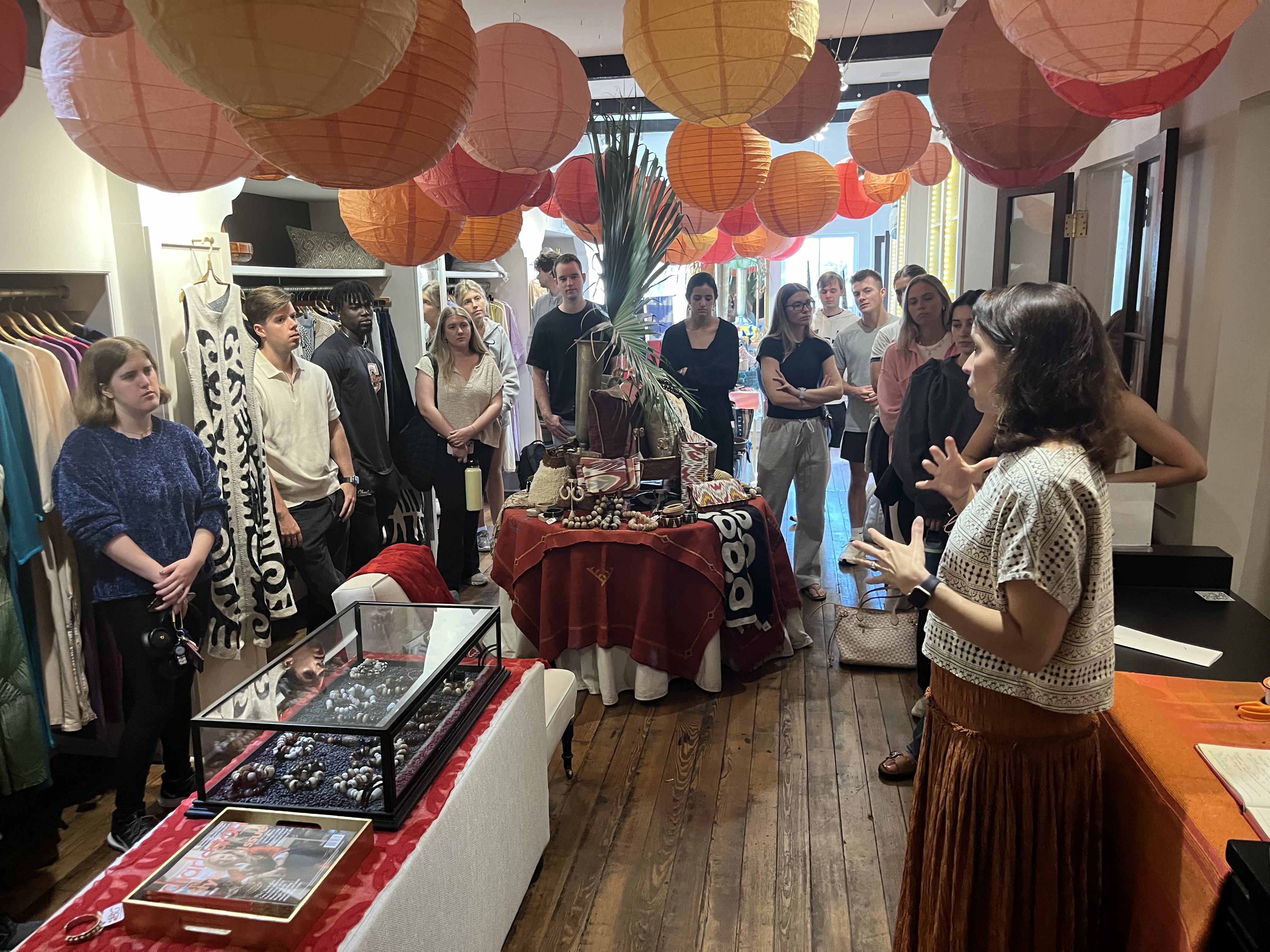 A woman in a storefront presenting to a group of students.