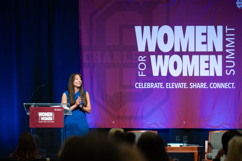 A woman speaking on stage at the Women for Women Summit event.