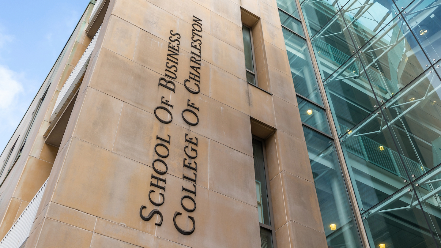 Exterior view of the School of Business at the College of Charleston, showcasing its modern architecture and signage.